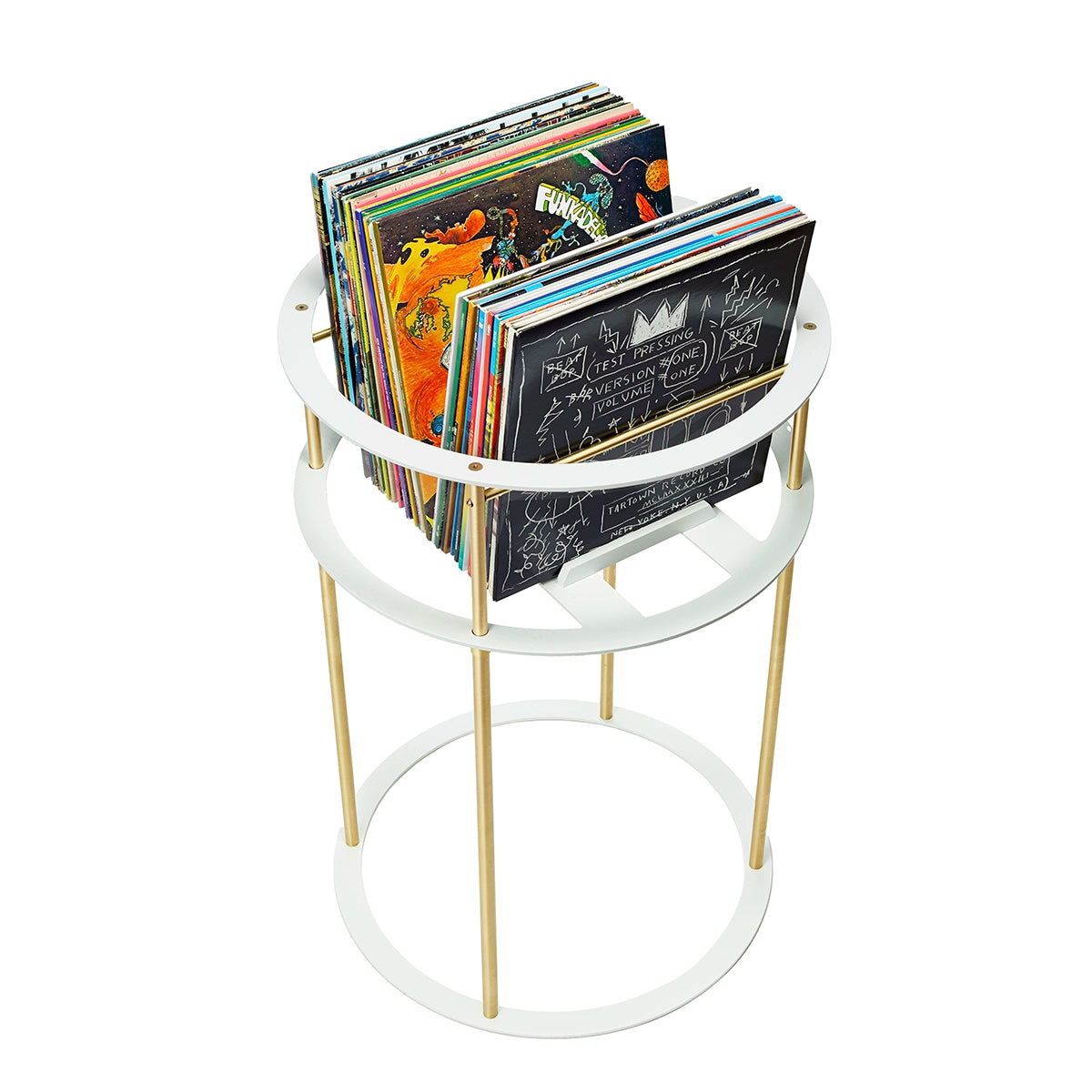 Right angle view of white and brass circular stand filled with vinyl records