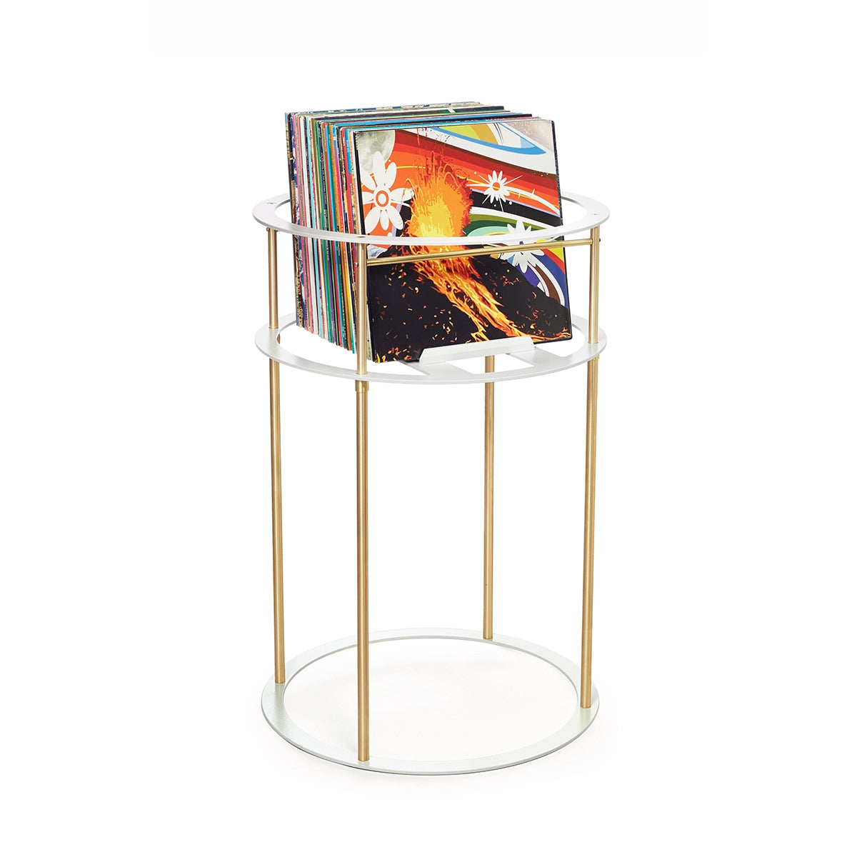 Colorful album cover art visible in front of a stack of vinyl records grouped inside a white and brass circular metal stand