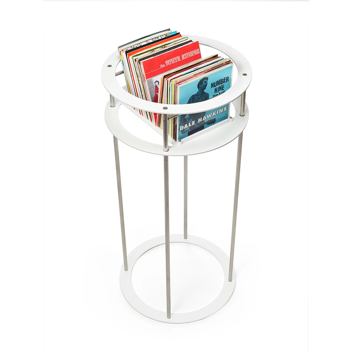 White circular metal stand containing many seven inch vinyl records